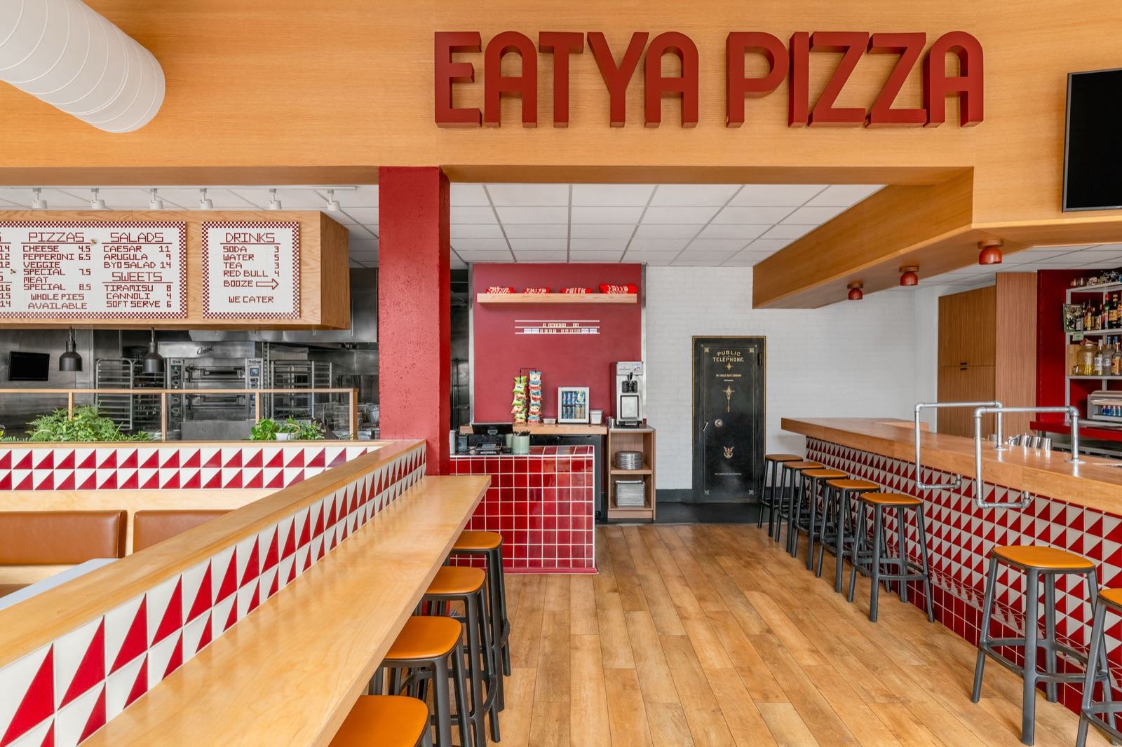 Retro pizzeria counter with dimensional signage, red-and-white triangle tile, and open kitchen — Damn Good Interiors interior design, LoDo, Denver, CO