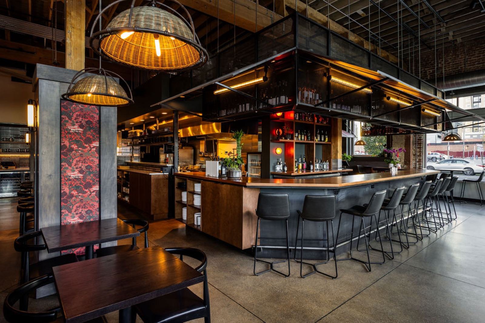 Bar and open kitchen with suspended glass liquor display, woven rattan pendant lights, and exposed timber ceiling — Damn Good Interiors interior design, Five Points, Denver, CO